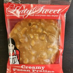 Photo of a Katy Sweet Creamy Pecan praline in a plastic wrapper.