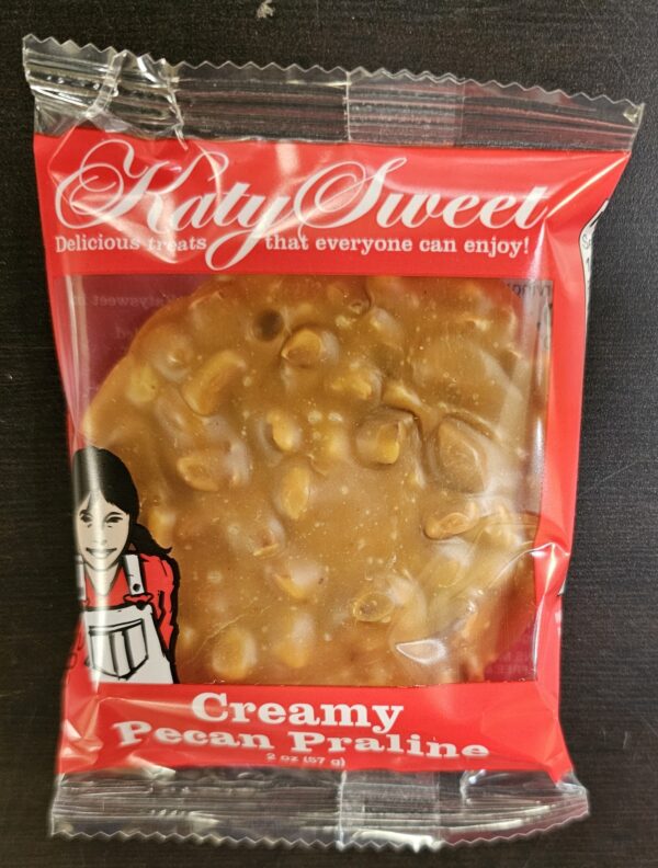 Photo of a Katy Sweet Creamy Pecan praline in a plastic wrapper.